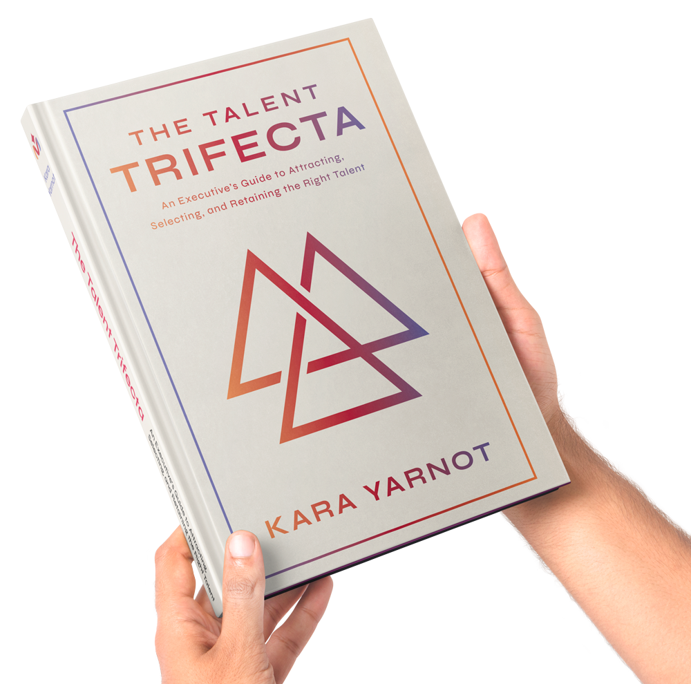 Hands holding a copy of The Talent Trifecta
