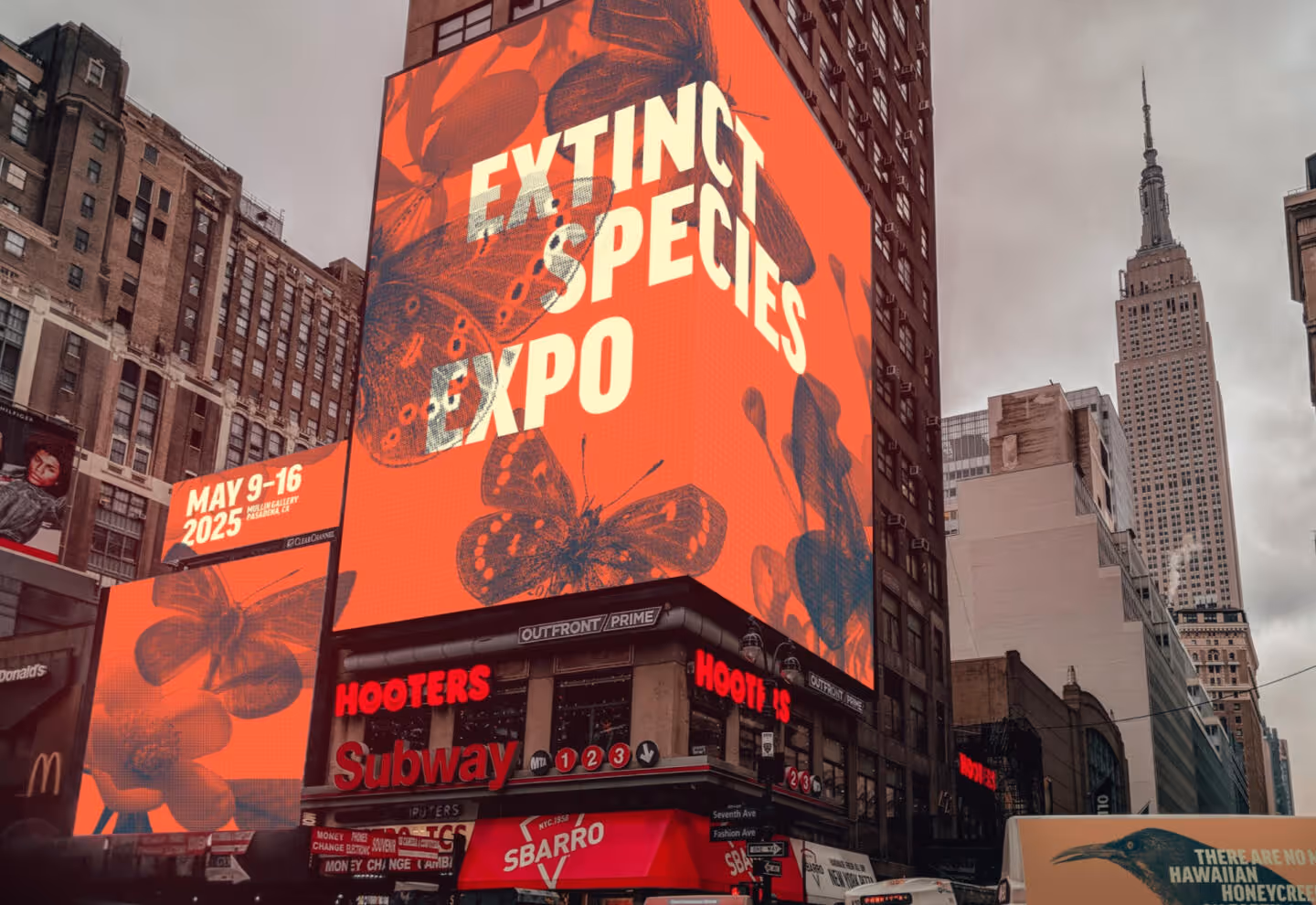 Defenders' extinct species expo being promoted on various screens in a city.
