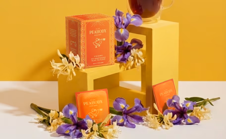 An AI-generated photo of honeysuckle iris oolong teabags and teabox. Iris and honeysuckle flowers are scattered around.