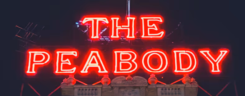 A neon red sign of The Peabody.