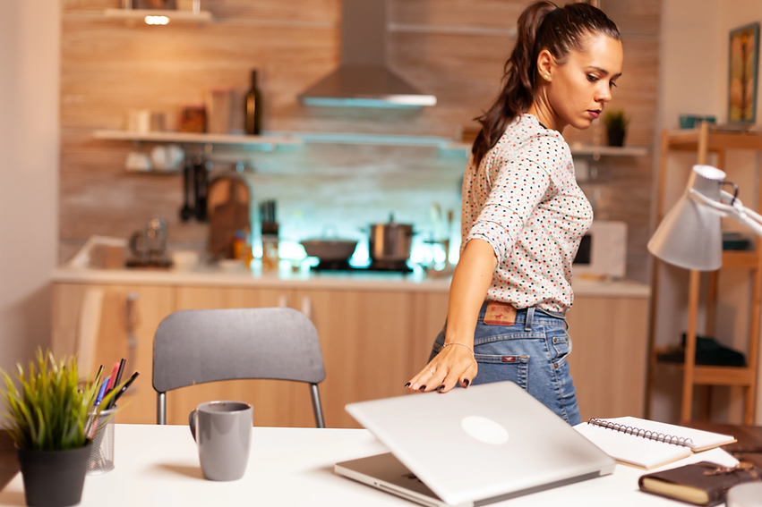 woman walking away from desk closing laptop