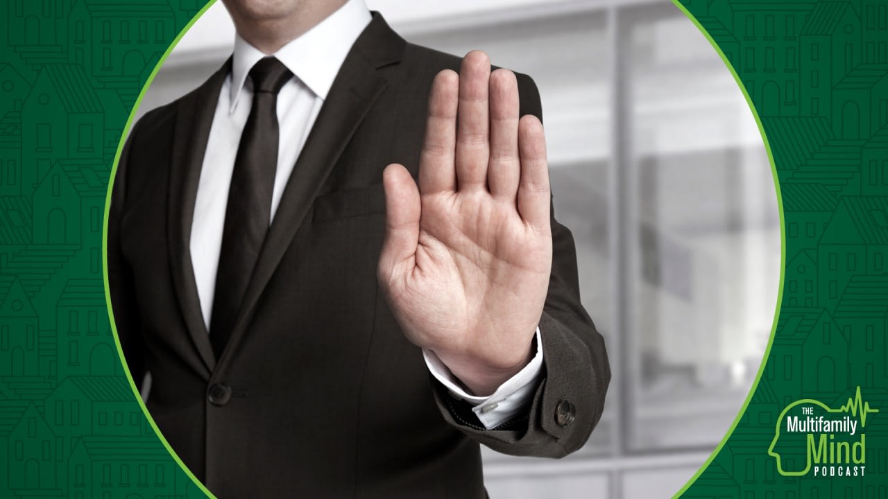 man in suit gives palm facing camera, "no" gesture