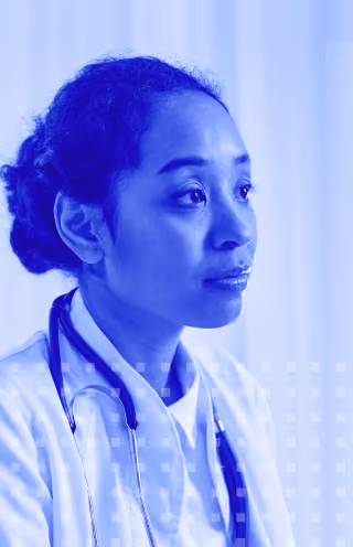 Portrait of a female doctor with a stethoscope around her neck looking to the side in a blue tone filter.