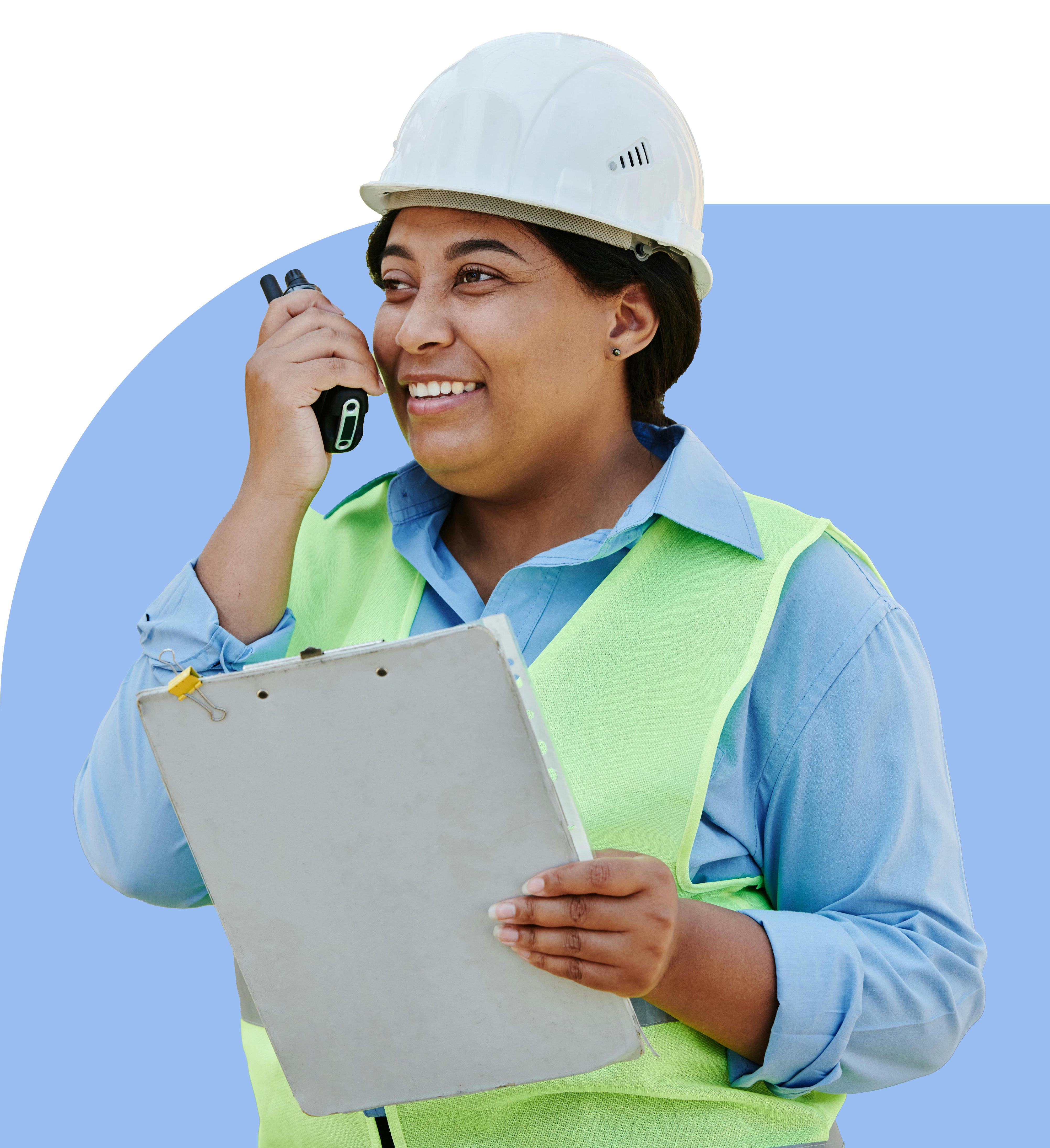 Smiling construction worker wearing a white hard hat and green safety vest, holding a walkie-talkie and a clipboard.
