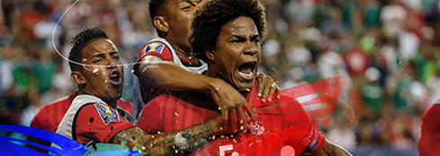 Three soccer players in red uniforms celebrating passionately on the field during a match.