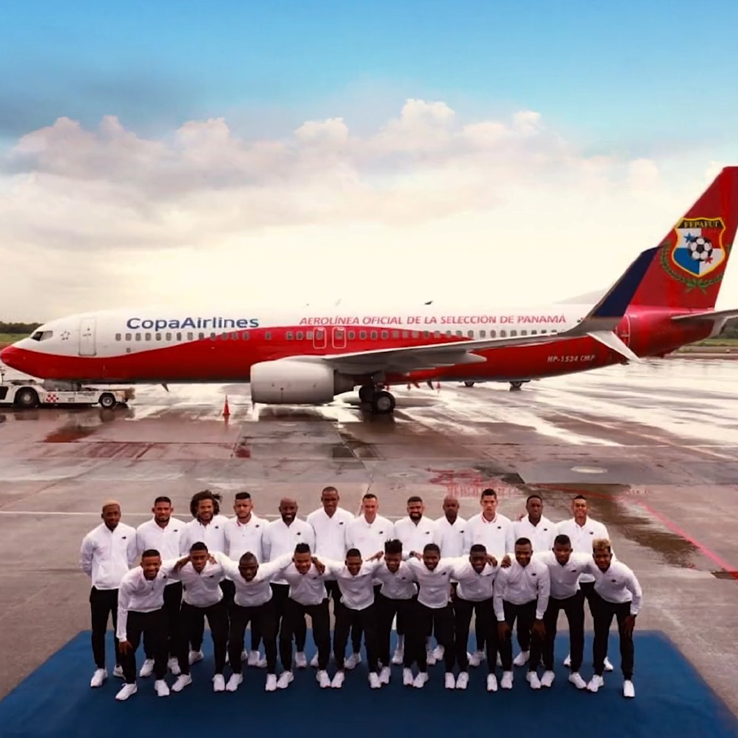 Panama national soccer team posing in two rows on tarmac in front of a Copa Airlines airplane with Panama team branding.