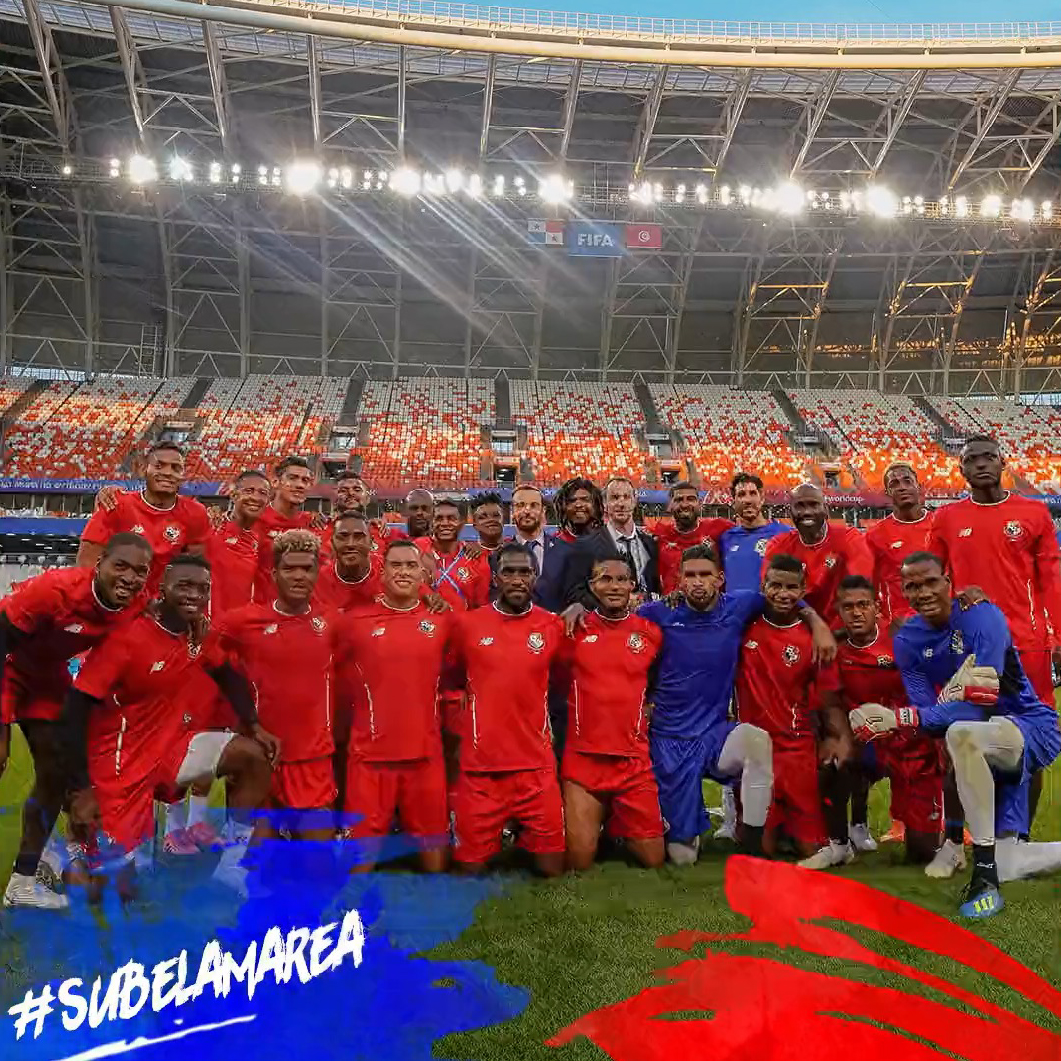 Panama national soccer team posing together on a soccer field inside a stadium under bright lights.