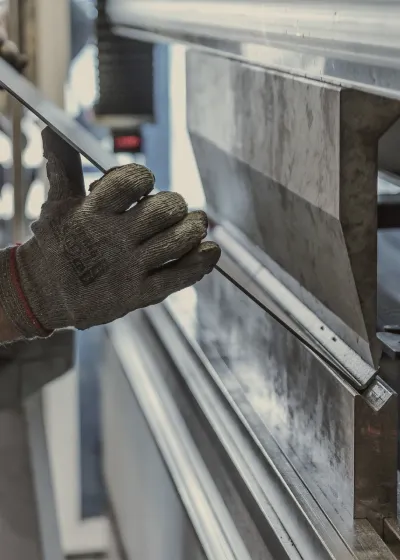 Worker bending metal using a machine
