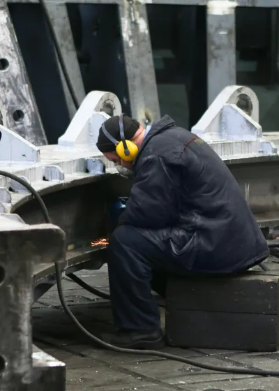 Worker grinding heavy structure