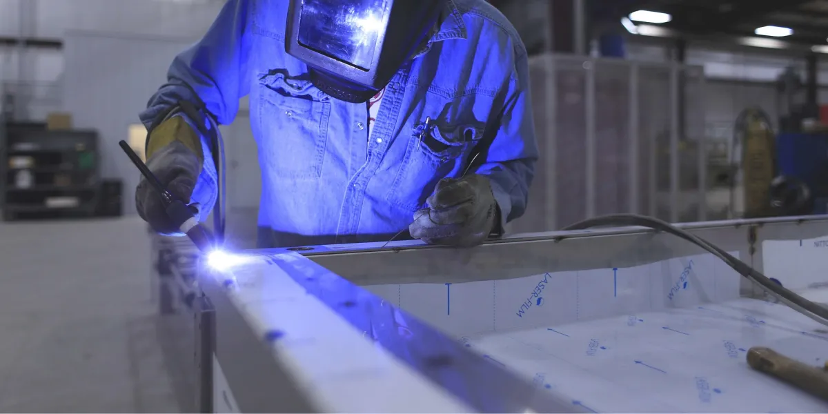 Welder applying touches to panel