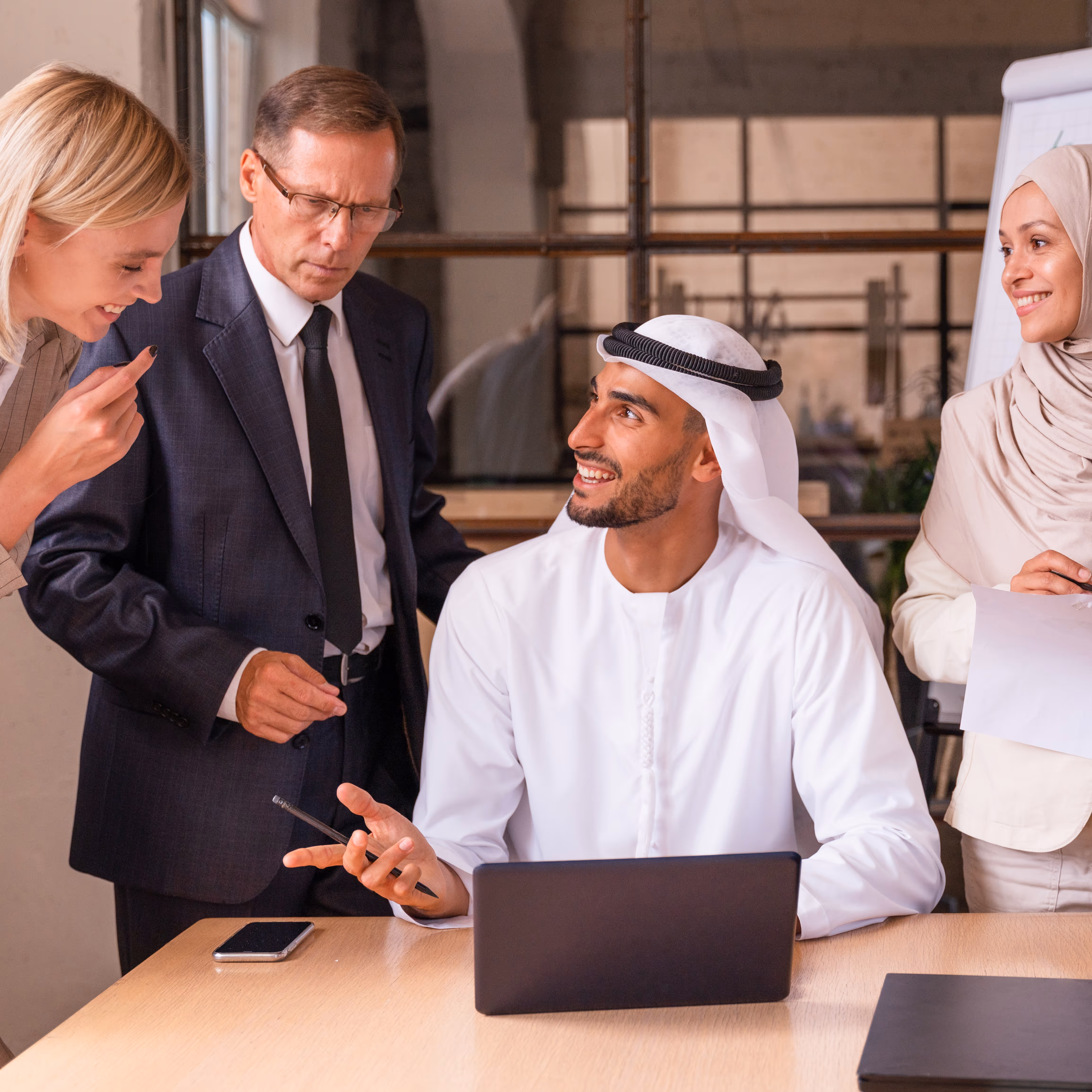 Diverse business colleagues having a discussion around a laptop in an office.