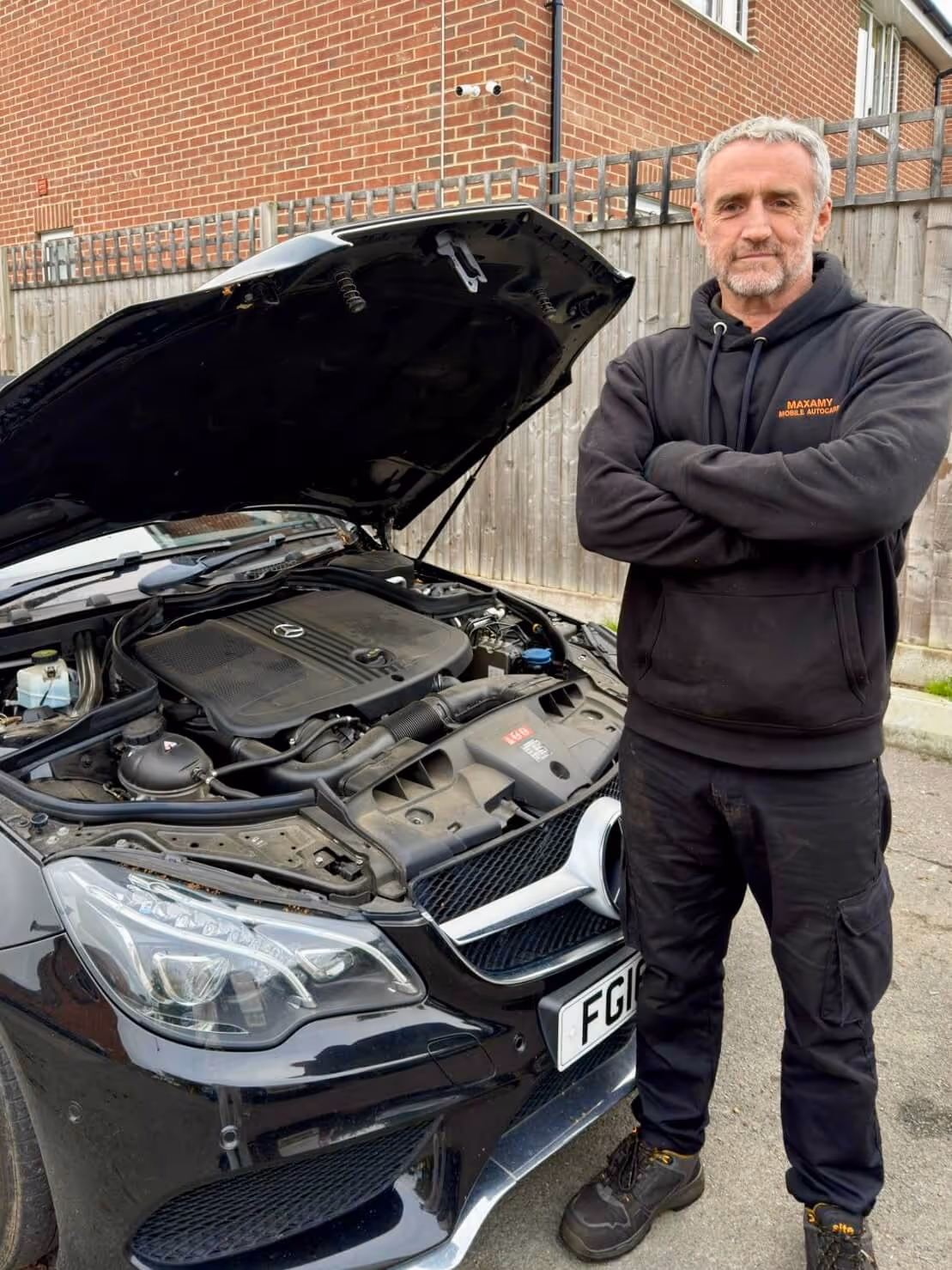Mobile mechanic Graeme standing beside a customer’s car during an at-home vehicle inspection
