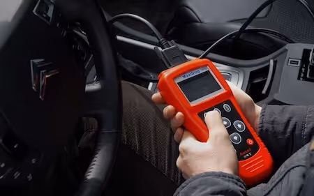 Mobile mechanic performing an OBD diagnostic scan inside a car to identify engine fault codes and warning lights in High Wycombe