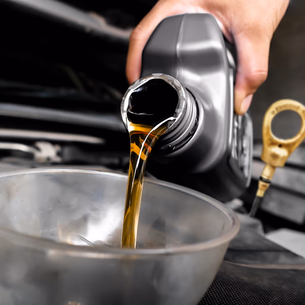 A Maxamy Mobile Autocare technician pre-measures fresh engine oil from a bottle into a container before a mobile oil change.