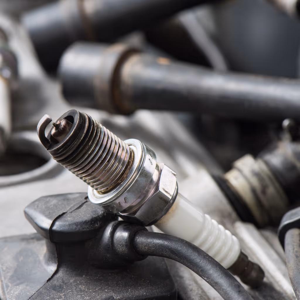 A close-up of a worn spark plug. We inspect plugs for fouling or wear to diagnose combustion issues and prevent long-term engine damage.