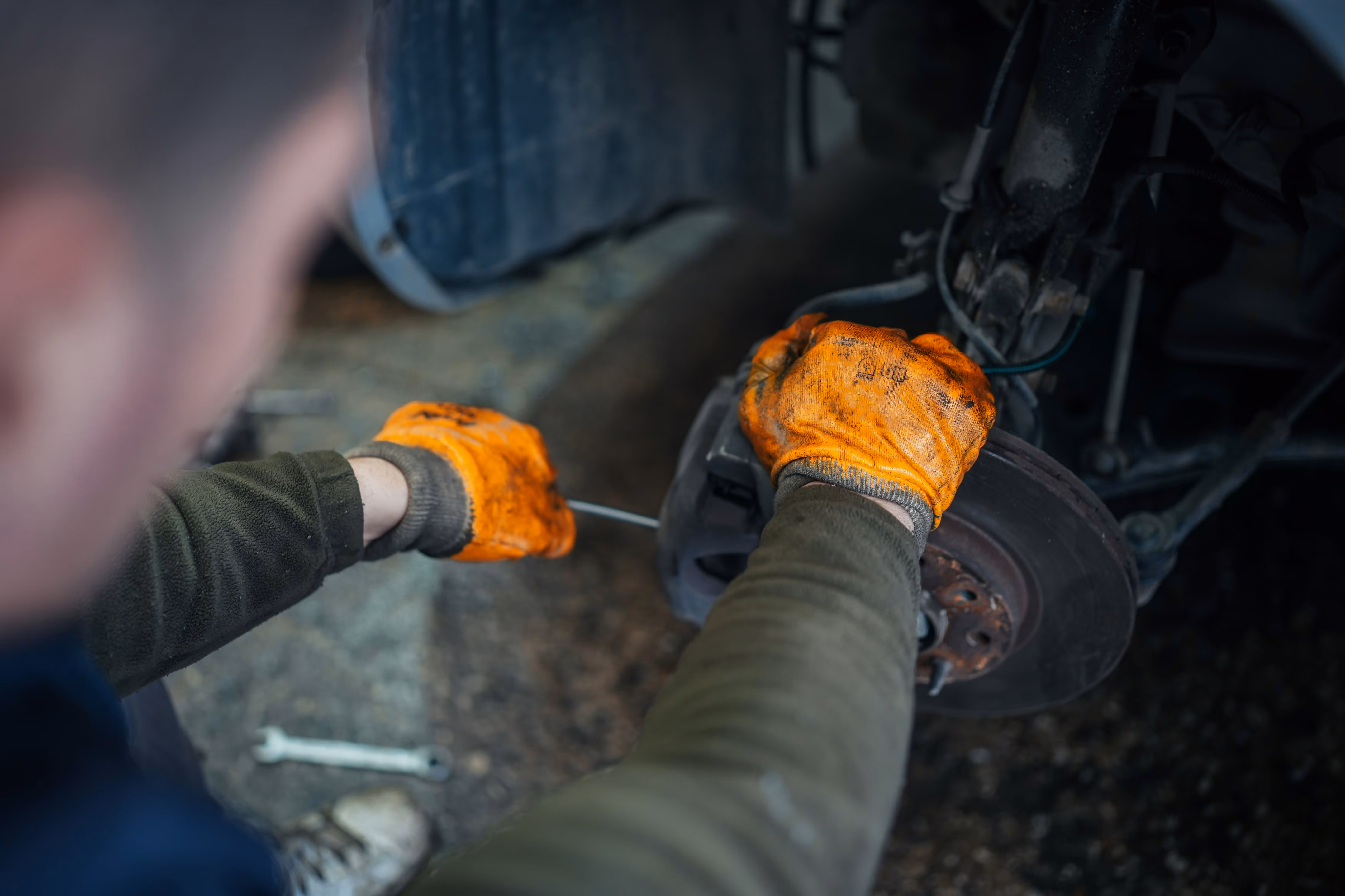 Mobile mechanic repairing a vehicle brake assembly as part of an on-site car repair service in Slough, Windsor and Maidenhead