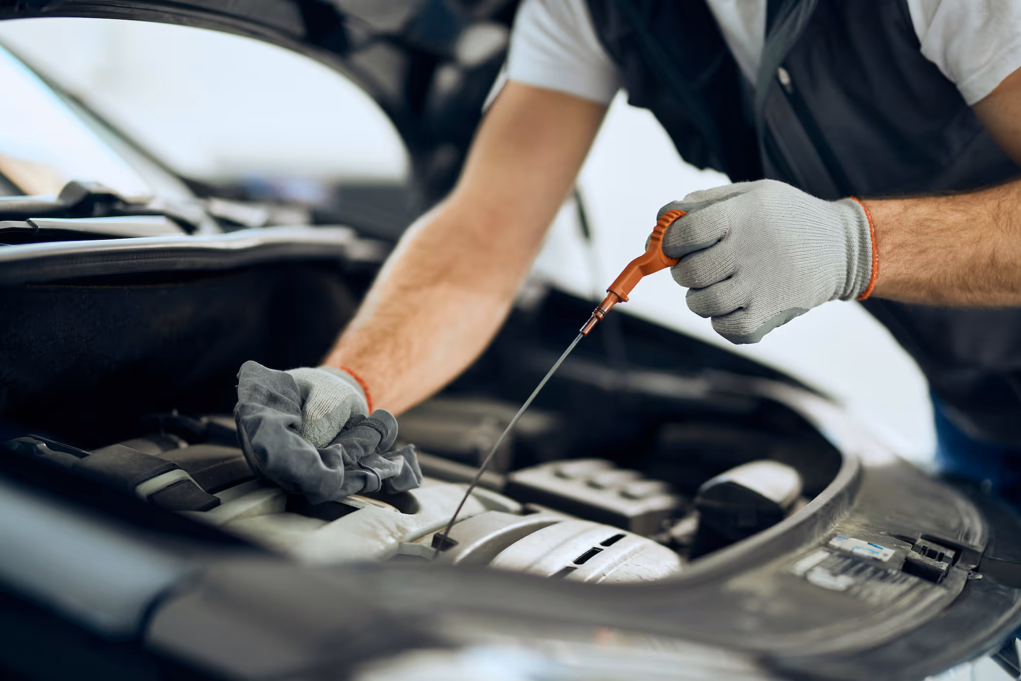Mobile mechanic checking engine oil level during a routine car service carried out at a customer’s home in Reading and nearby areas