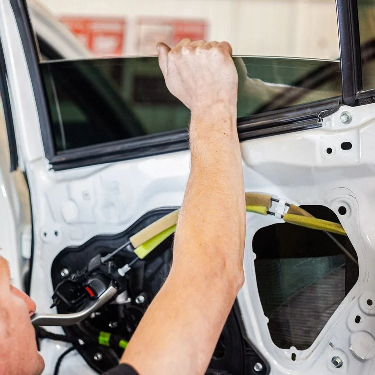 Technician repairing an electric car window inside the door panel, replacing the window regulator/mechanism for smooth, reliable operation. Maxamy Mobile Autocare offers mobile bodywork and door mechanism repairs at your home or workplace across Maidenhead, Slough, Windsor and nearby towns.
