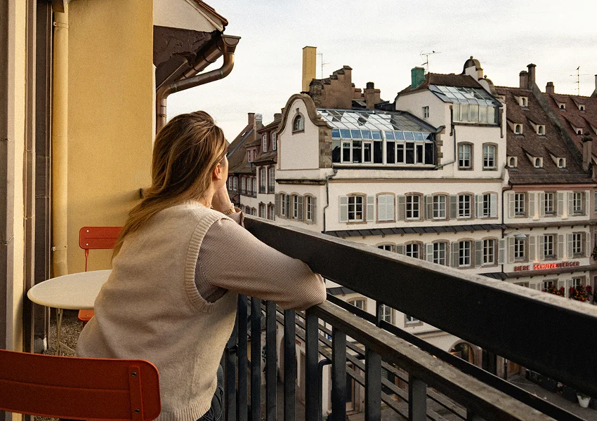 photo d'une résidente qui regarde la place gutenberg depuis le balcon du coworking