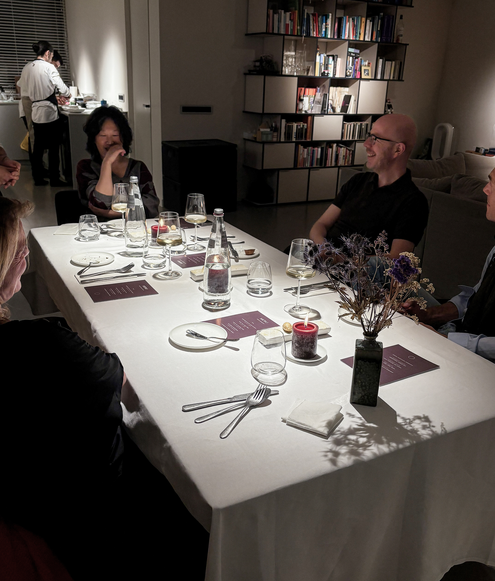 A dinner table with happy guests around it