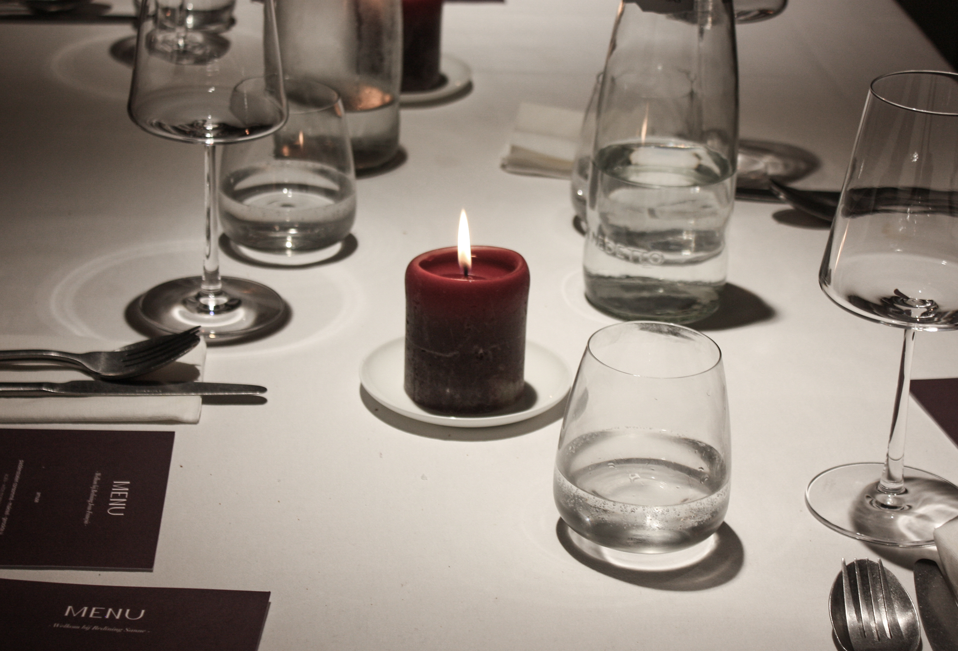 A decorated table with a candle and wineglasses