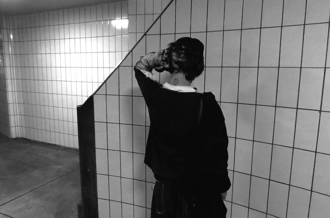 Person in a tiled stairwell, seen from behind