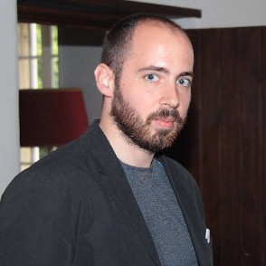 A man with a beard standing in a room.