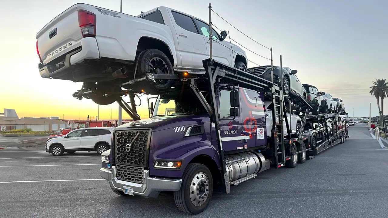 New GB Cargo car hauling truck in a parking lot