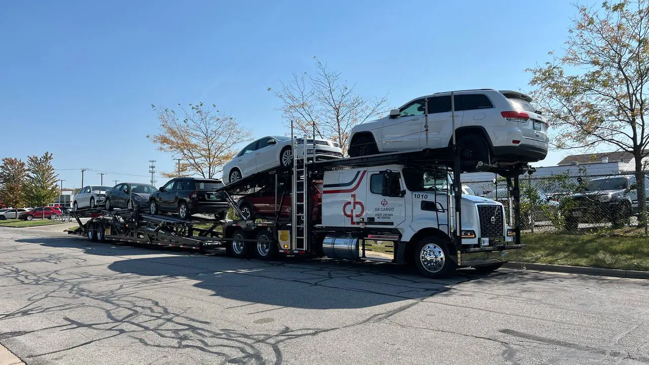 A loaded car hauling truck parked on the side of the road.