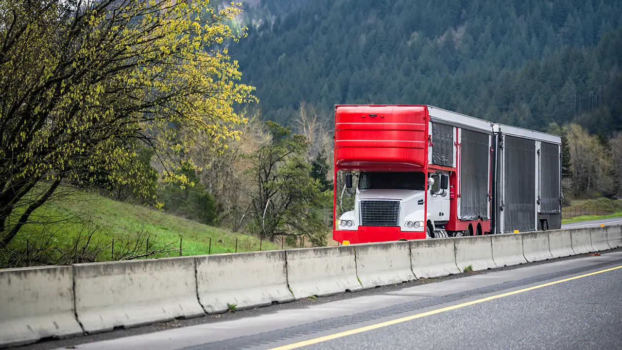 Car hauling truck with enclosed trailer on a highway.