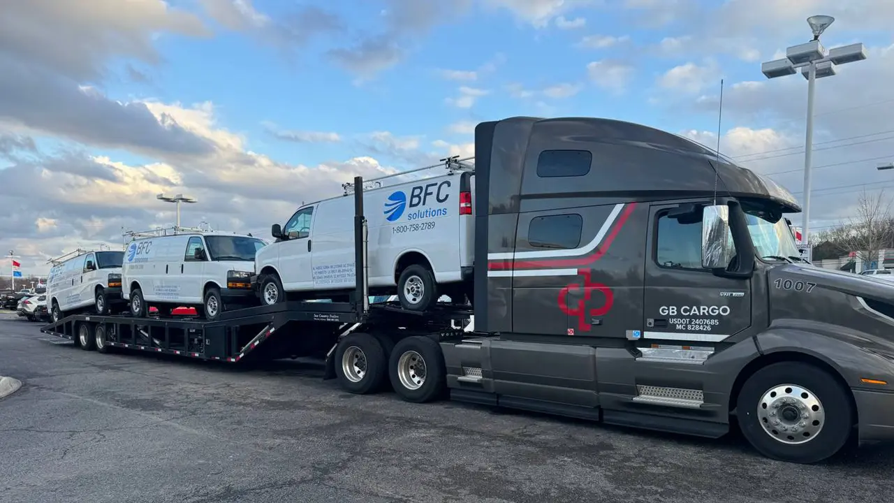 GB Cargo car hauler with custom trailer loaded with 3 white vans.
