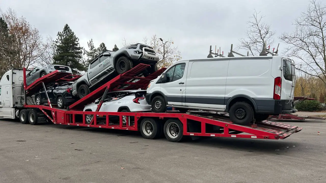 A car hauler with loaded cars on a custom trailer