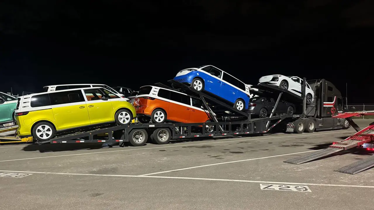 Electric vans loaded on a custom trailer of a car hauler
