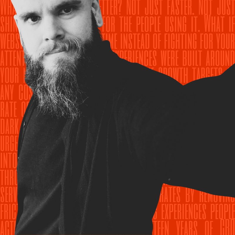 Black-and-white close-up portrait of Jon Crowder, a bearded man in a black shirt with an orange background featuring faint text.