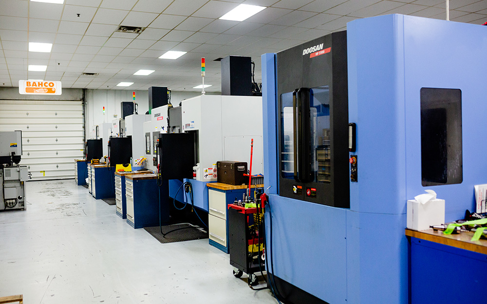 Row of Doosan CNC machining centers at JGA Space & Defense, demonstrating high-volume precision manufacturing capacity for aerospace and defense contracts.