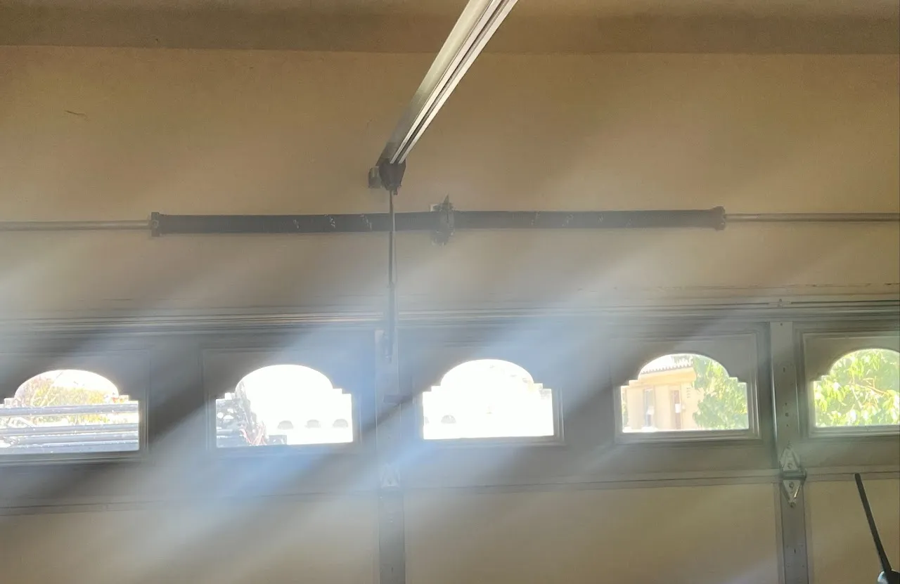 Sunlight beams streaming through decorative arched windows of a garage door.