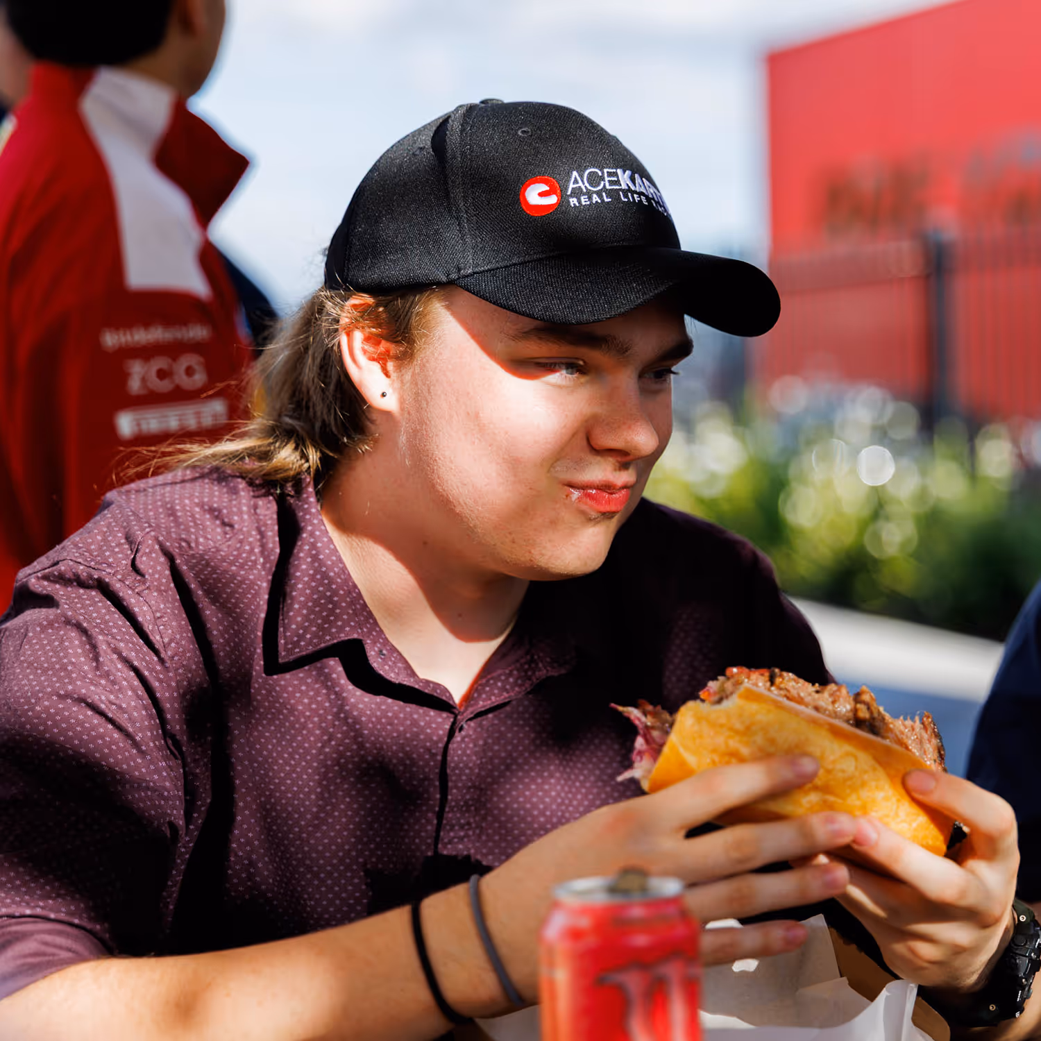 Person eating a BBQ sandwich outdoors