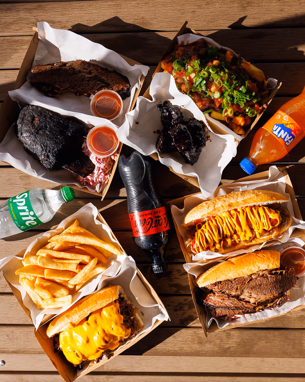 Platter of skewered meat, fried snacks, and dipping sauces.