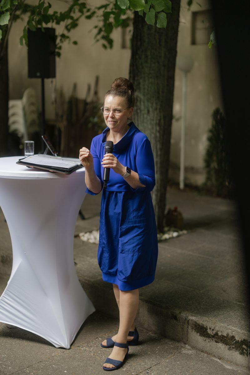 Kati Kreyser leitet eine freie Zeremonie, am Stehtisch mit ihrer Redemappe