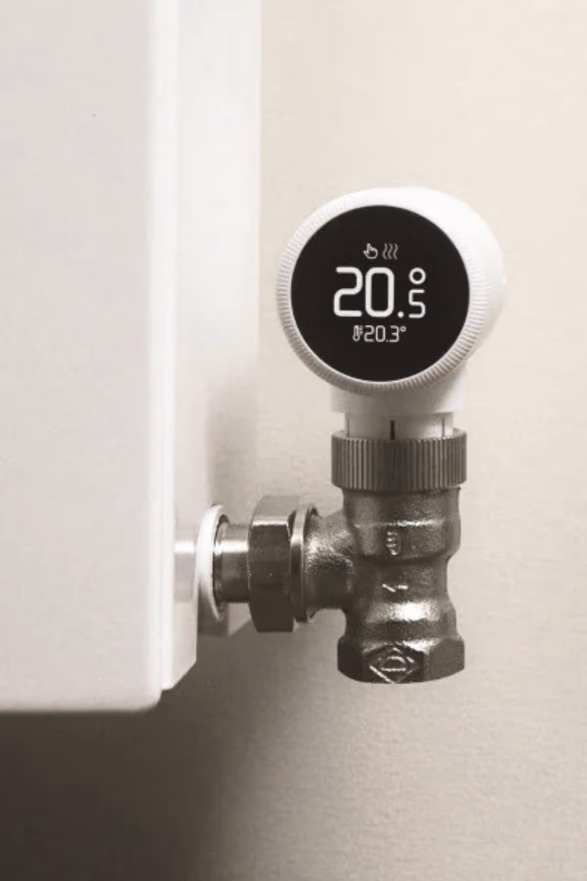 Digital thermostat valve attached to a radiator pipe showing temperature 20.5°C