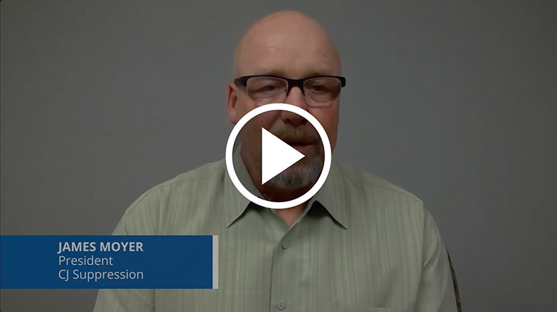 Man wearing glasses and a light green shirt against a plain gray background, with a video play icon overlay.