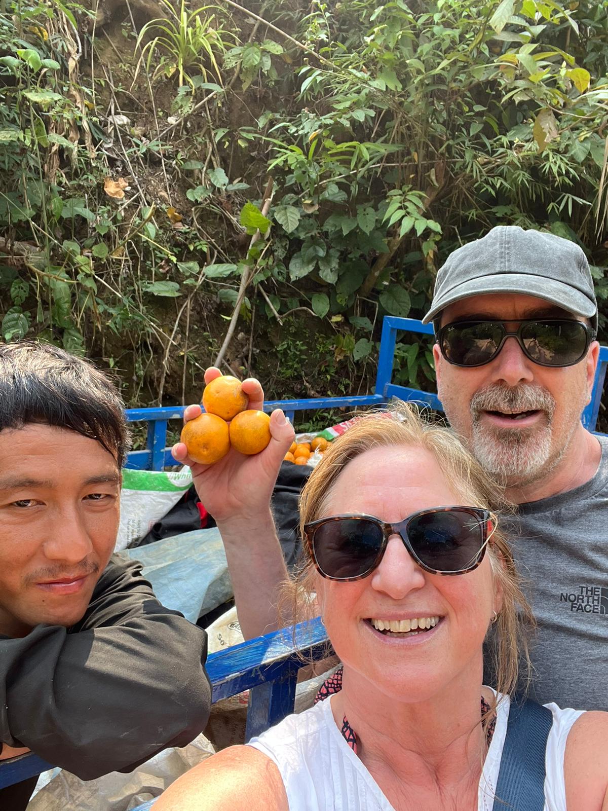 retirees buying fruit from man with van fruit seller in Laos