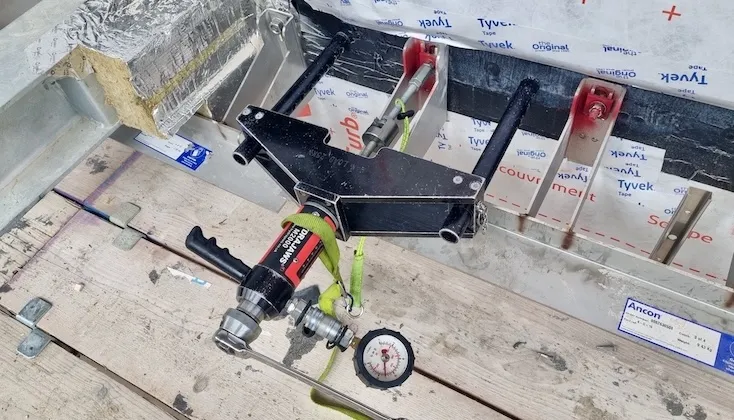 Pull testing of masonry support unit anchors.