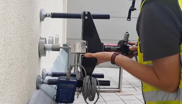 Adhesion pull off testing of external wall insulation system.