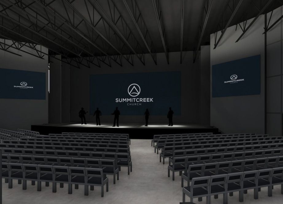 Dark auditorium with empty rows of gray chairs facing a stage where five silhouetted figures stand beneath large screens displaying Summit Creek Church logo.