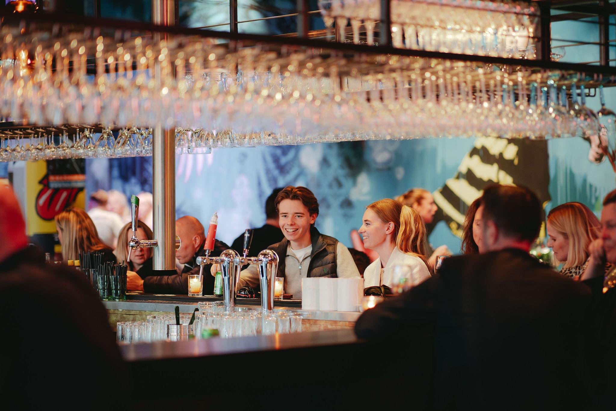 Gasten aan de bar van BAUT Backstage