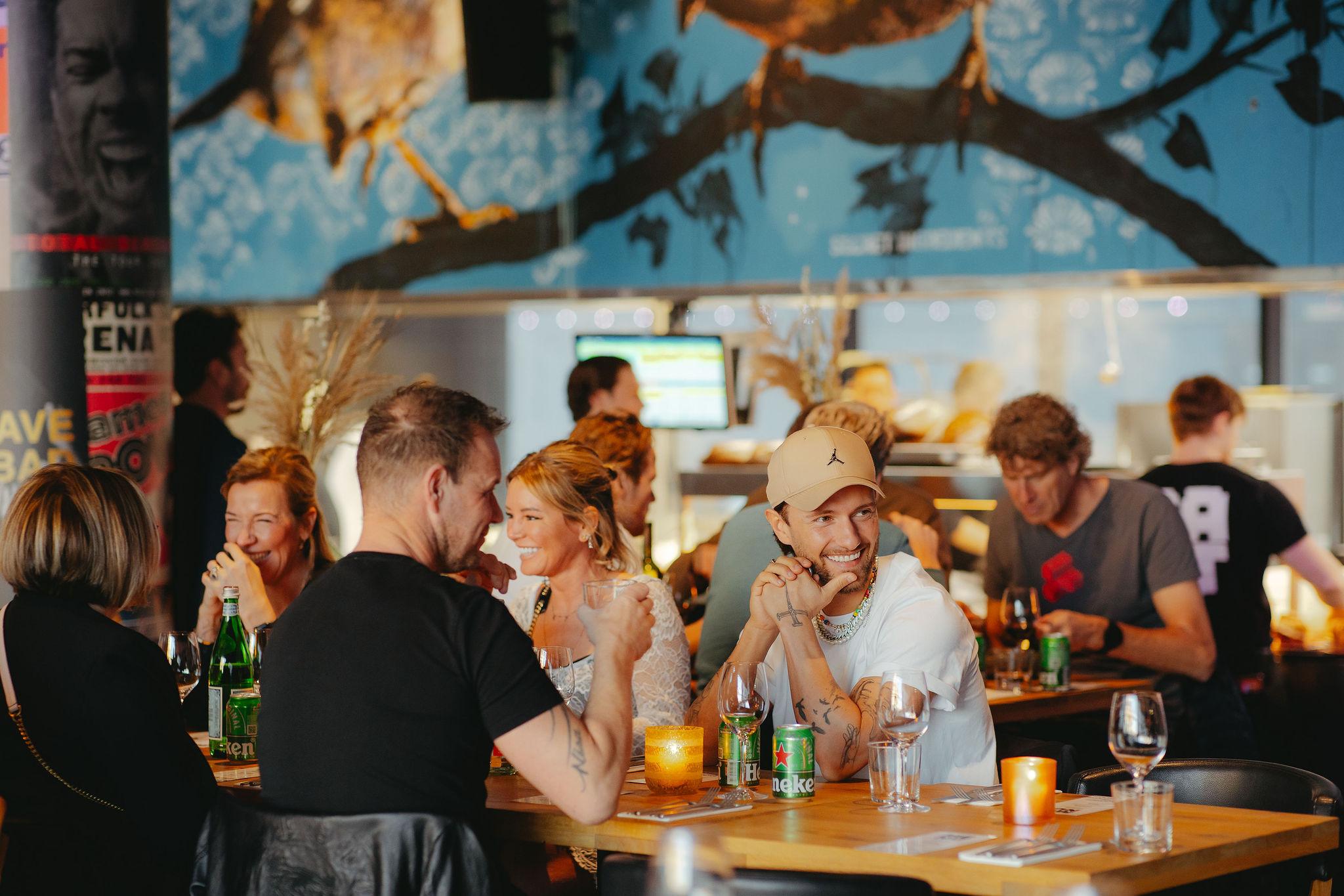 Diner aan tafel bij de open keuken van BAUT Backstage