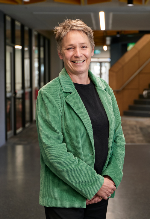 Dr Eveline Gebhardt standing in an office smiling with a green jacket on