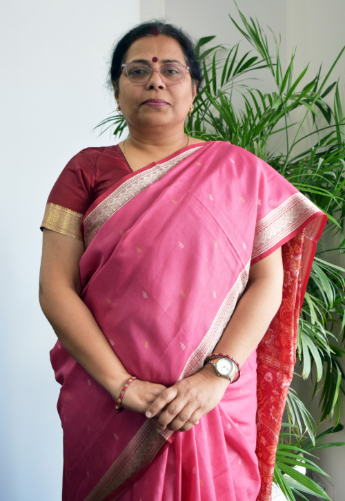 Dr Priyanka Sharma posing in front of a white wall