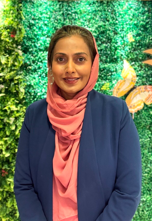Kris Sundarsagar posing in front of a green feature wall